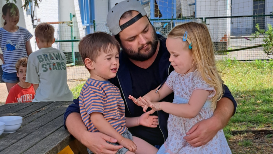 Medewerker BKO met twee kinderen op de schoot